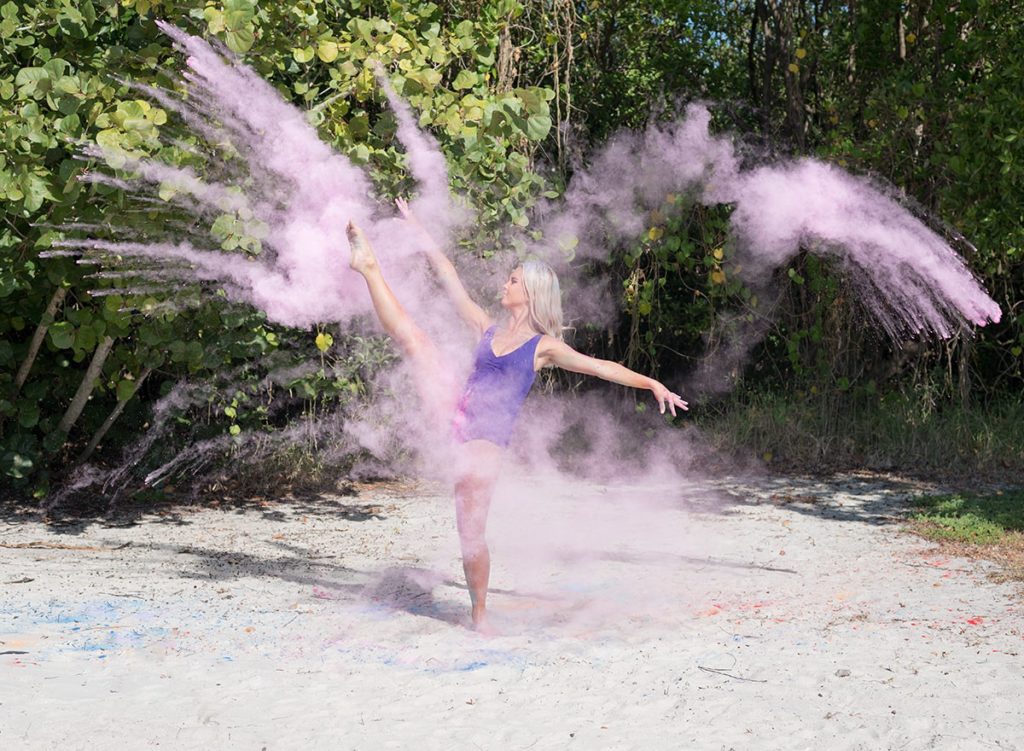 Senior girl dancing with pink chalk dust