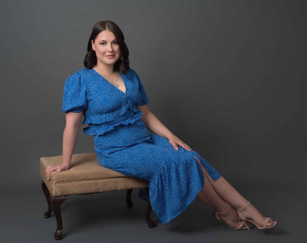 Lady in a blue dress sitting on an ottoman