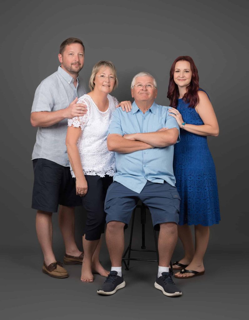 Parents with adult kids posing for in studio portrait